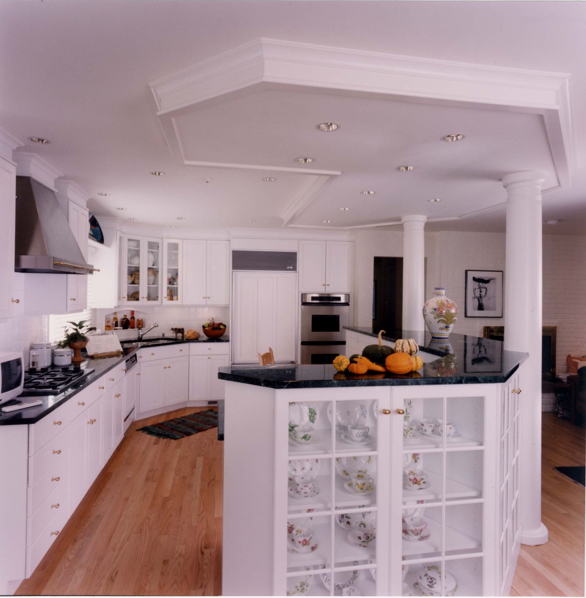 White kitchen with island, cabinets, appliances, and a central column.
