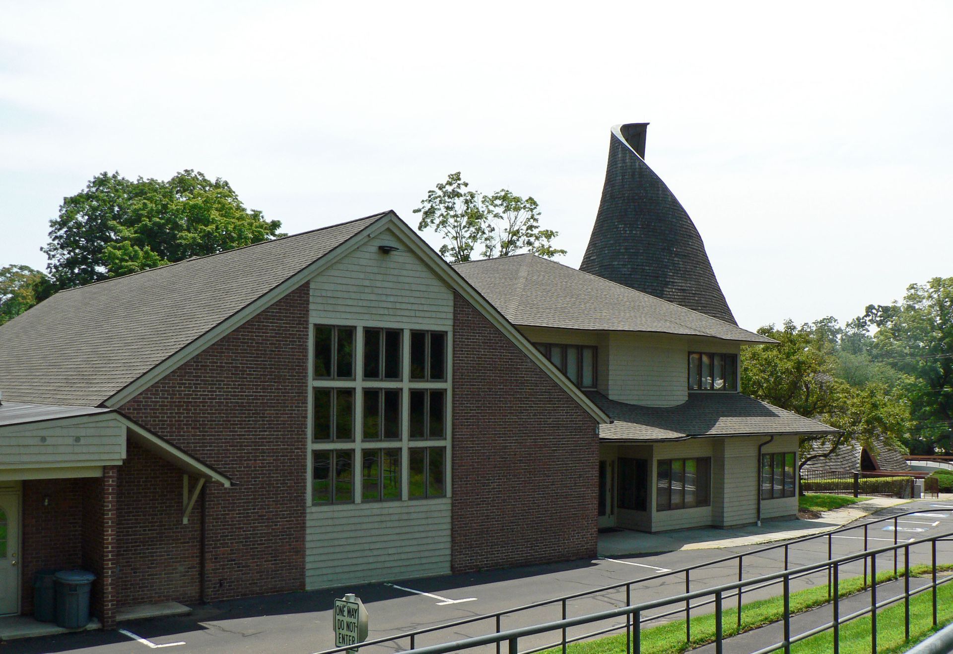 Brick building with a unique, cone-shaped roof and multiple windows.