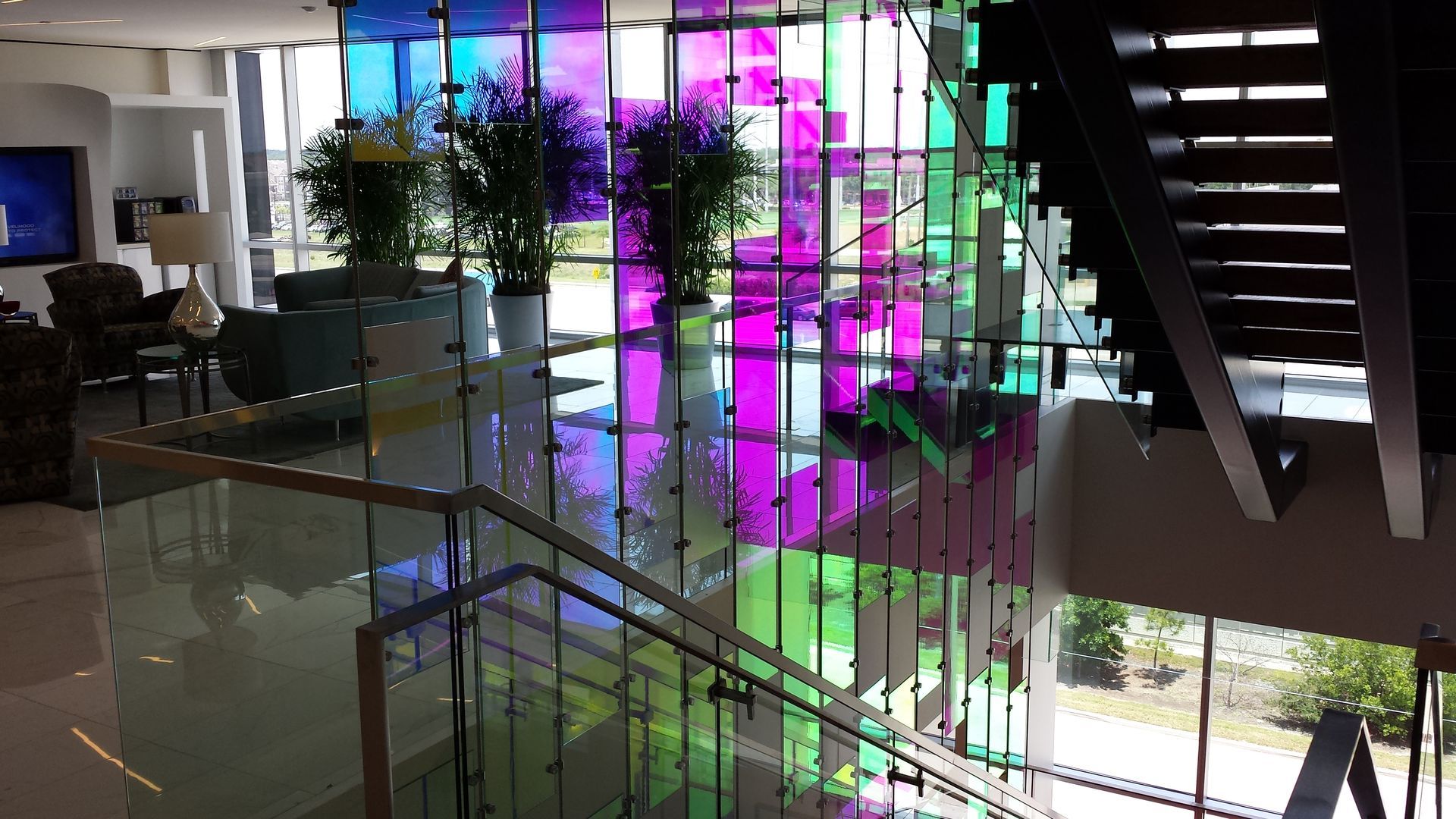 A lobby with a staircase and a stained glass window