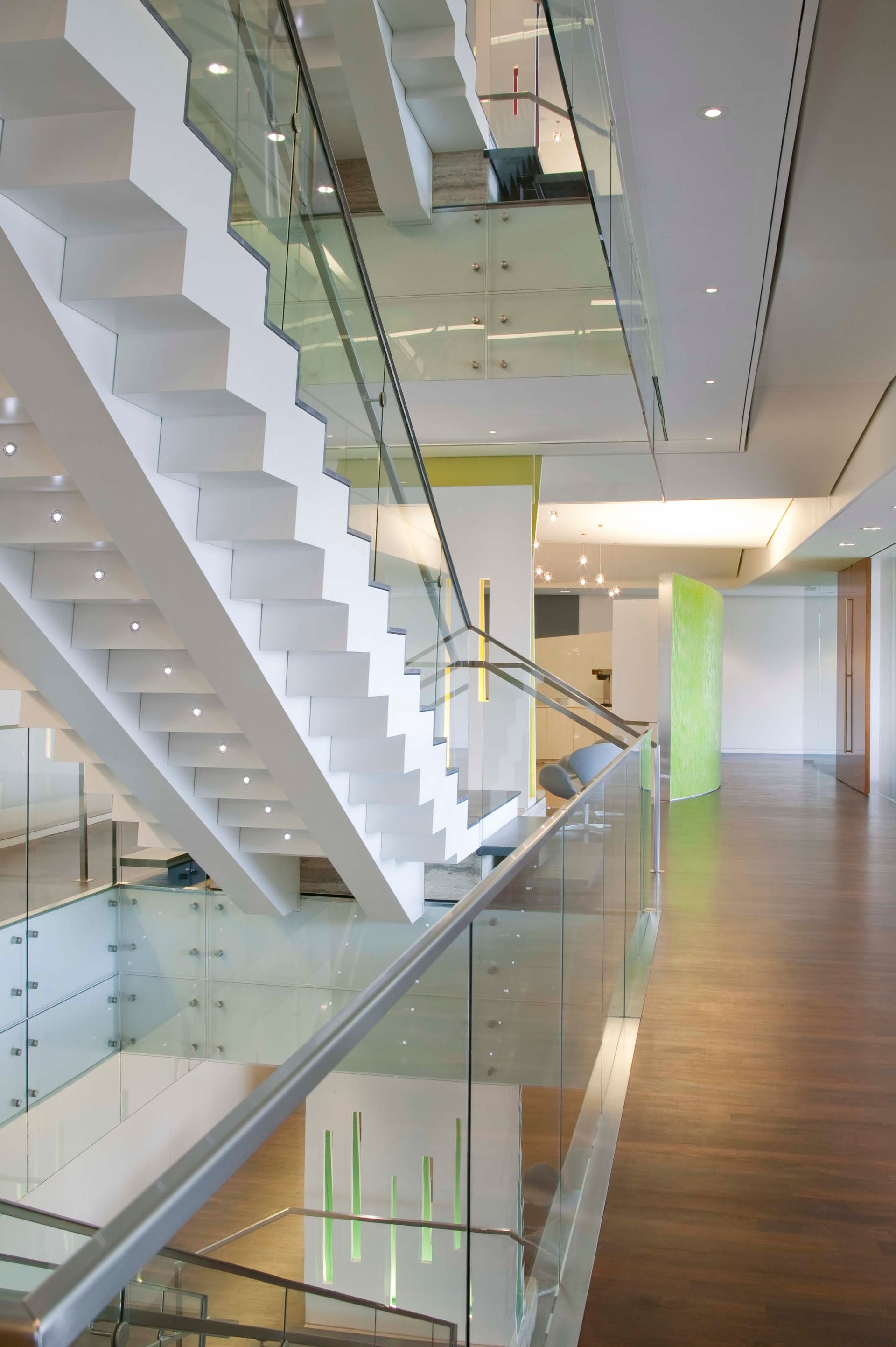 A staircase in a building with a glass railing