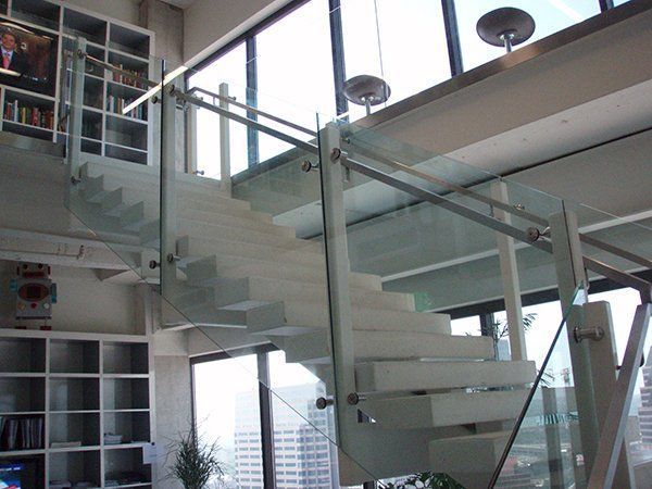 A Staircase with A Glass Railing in A Living Room
