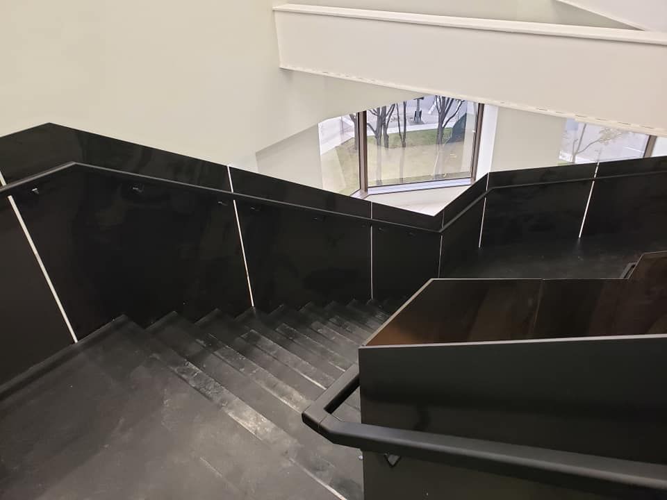 A Set of Stairs in A Building with A Black Railing