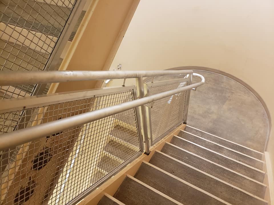 A Staircase with A Metal Railing and Wooden Steps