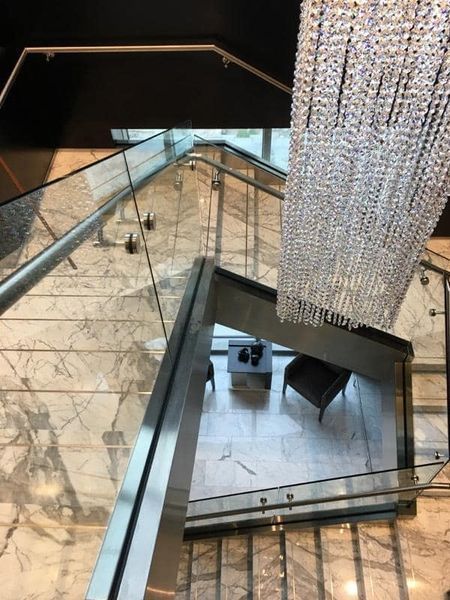 An Aerial View of A Staircase with A Chandelier Hanging from The Ceiling