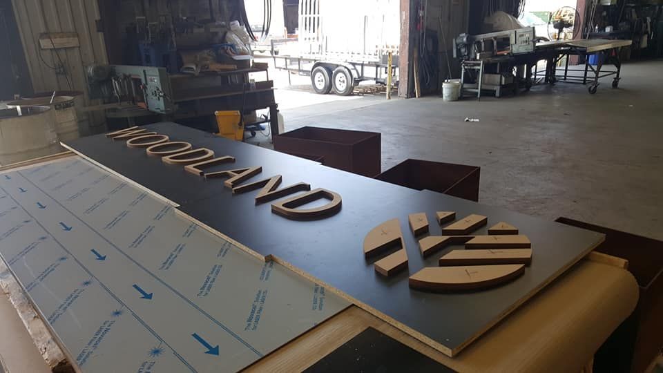 A Large Wooden Sign Is Sitting on Top of A Table