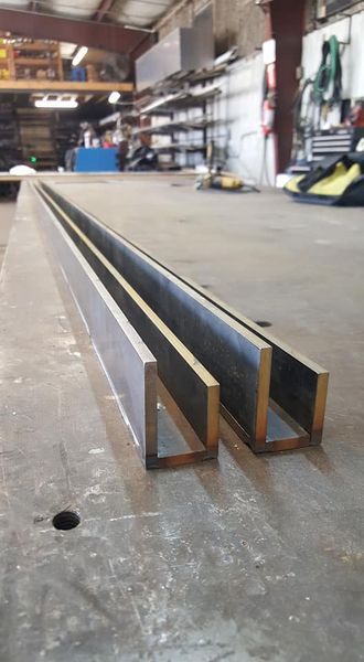 Two Pieces of Metal Are Sitting on Top of A Table in A Factory