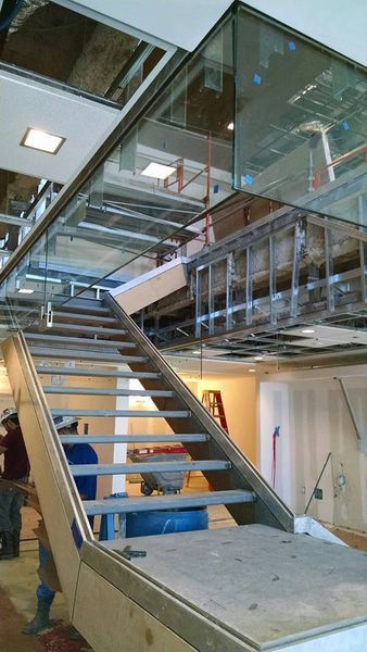 A Staircase with A Glass Railing Is Being Built in A Building