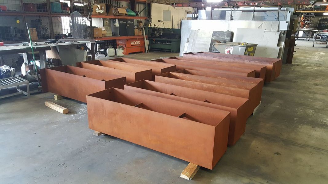 A Row of Metal Planters Are Sitting on Top of Each Other in A Warehouse