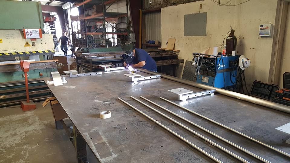 A Man Is Working on A Piece of Metal in A Factory