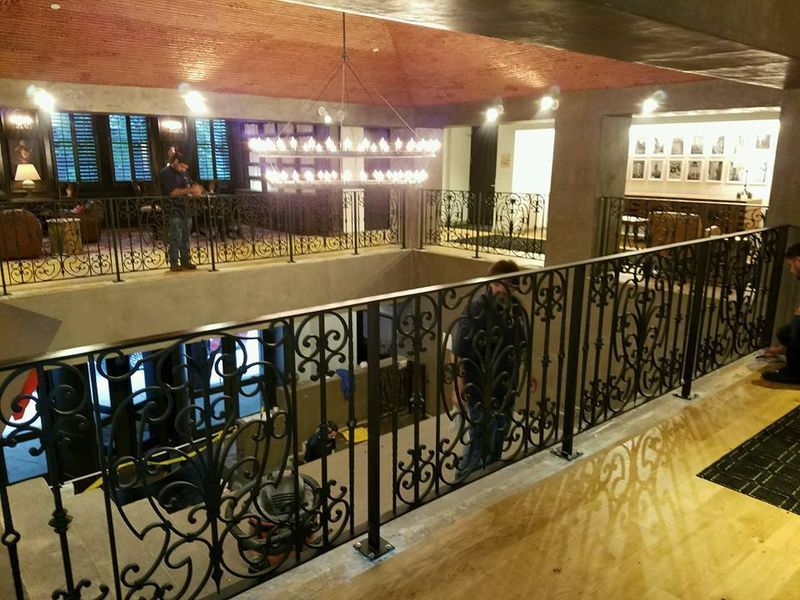 A Man Is Standing on A Balcony with A Wrought Iron Railing