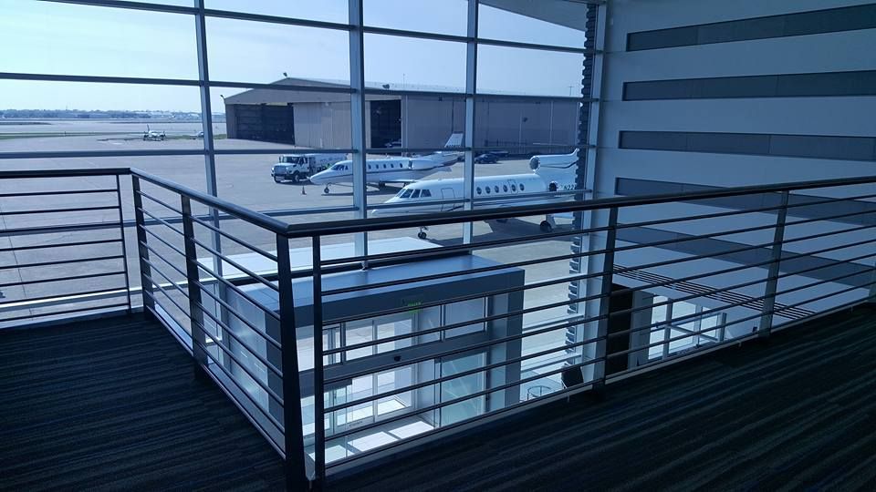 A View of An Airport from A Balcony with Planes Parked in The Background