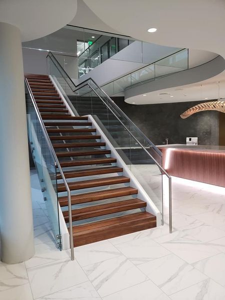 A Wooden Staircase with A Glass Railing in A Building