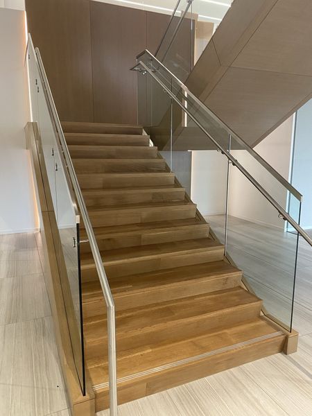 A Wooden Staircase with A Glass Railing in A Building