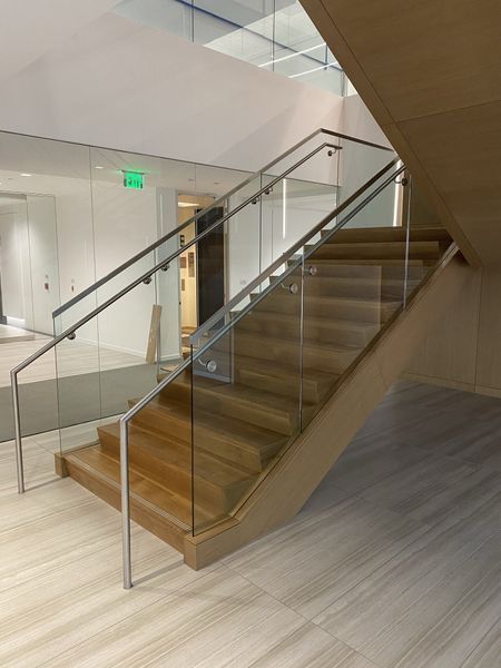 A Wooden Staircase with A Glass Railing in A Building