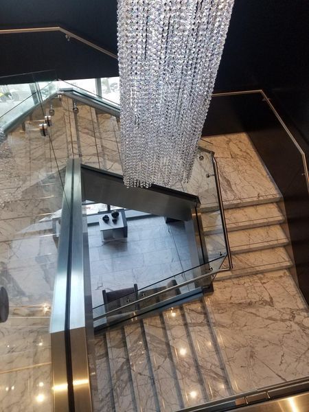 A Staircase with A Large Chandelier Hanging from The Ceiling