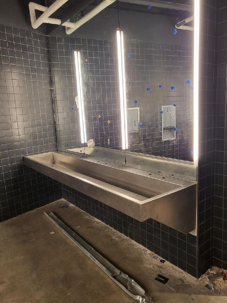 A Bathroom with A Stainless Steel Sink and Mirrors