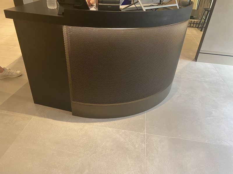 A Person Is Standing Behind a Curved Counter in A Room