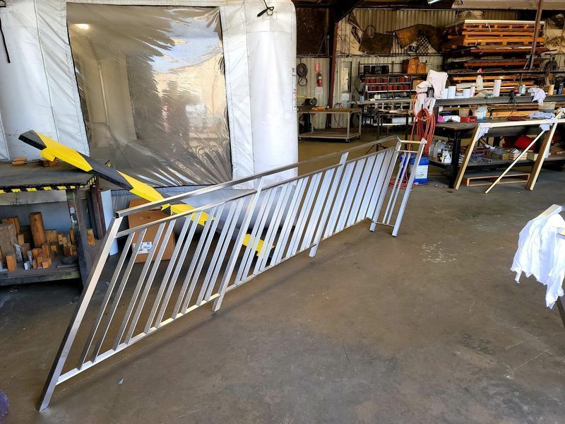 A Stainless Steel Railing Is Sitting in A Warehouse