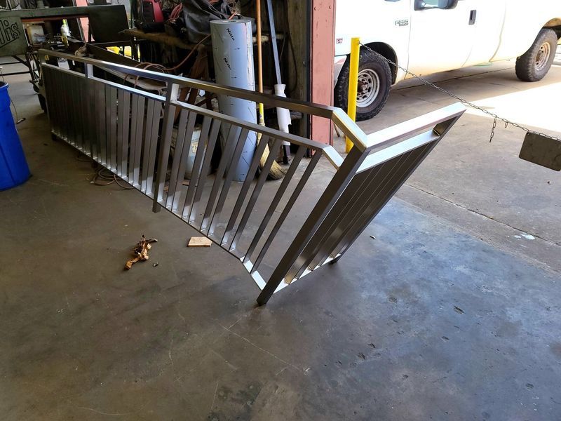 A Stainless Steel Railing Is Sitting on The Ground in Front of A White Truck