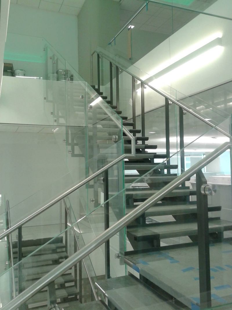 A Staircase with A Glass Railing in A Building