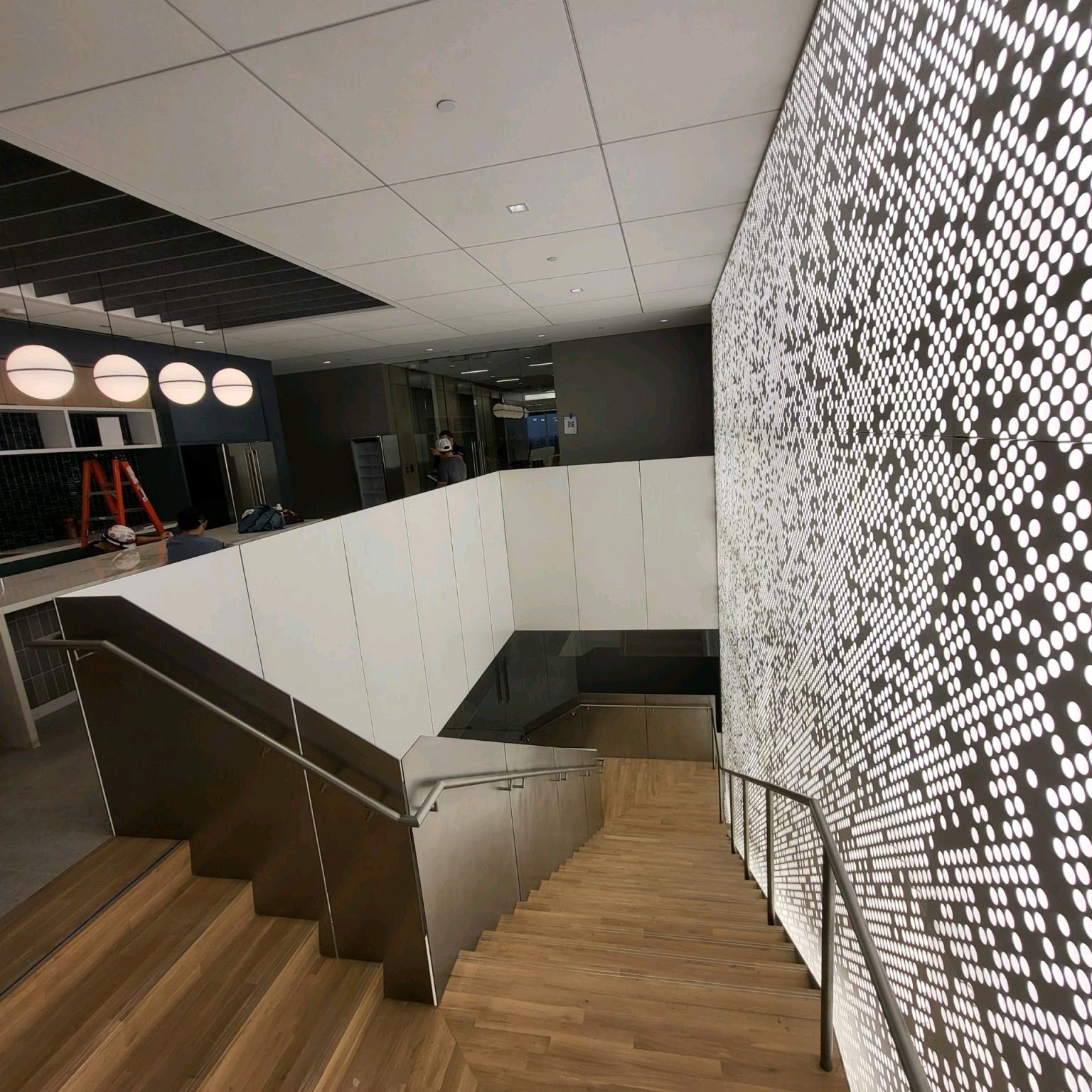 A staircase with a patterned wall behind it