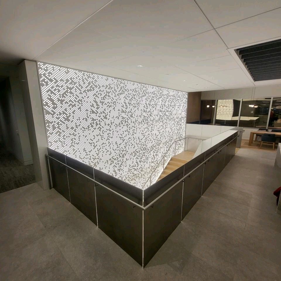 A room with a staircase and a wall with a pattern on it