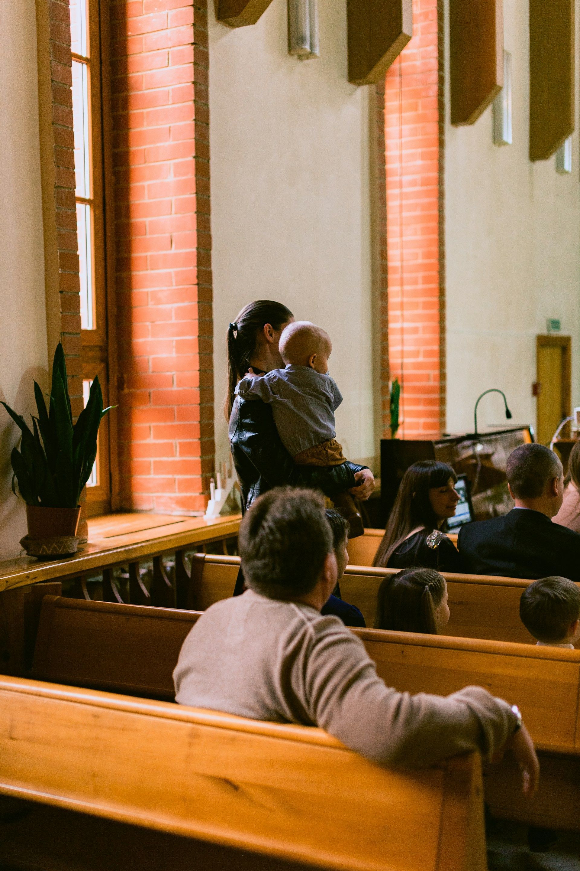 White barn with green roof, surrounded by a cornfield and lush greenery under a bright blue sky with puffy white clouds.