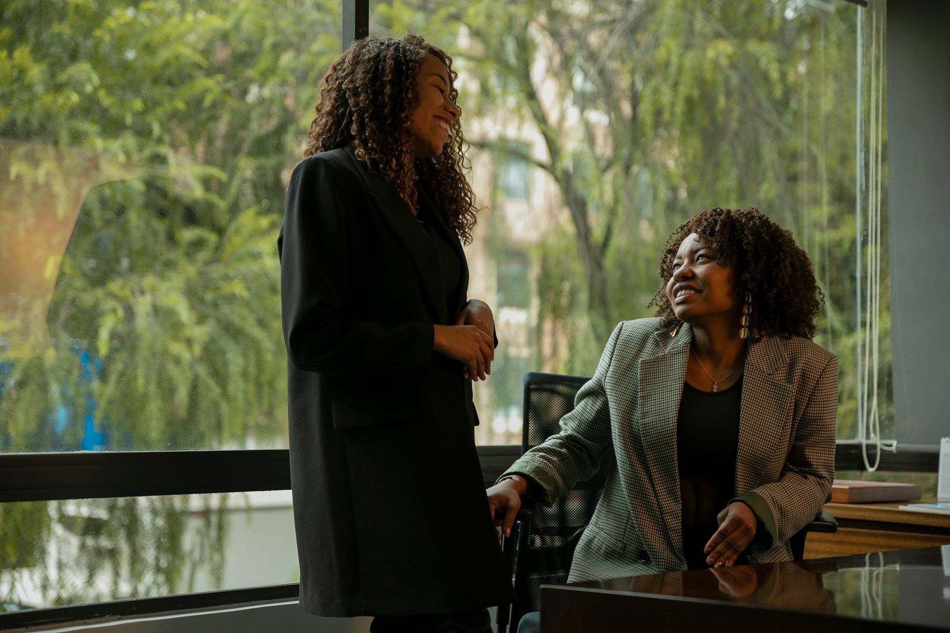 White barn with green roof, surrounded by a cornfield and lush greenery under a bright blue sky with puffy white clouds.