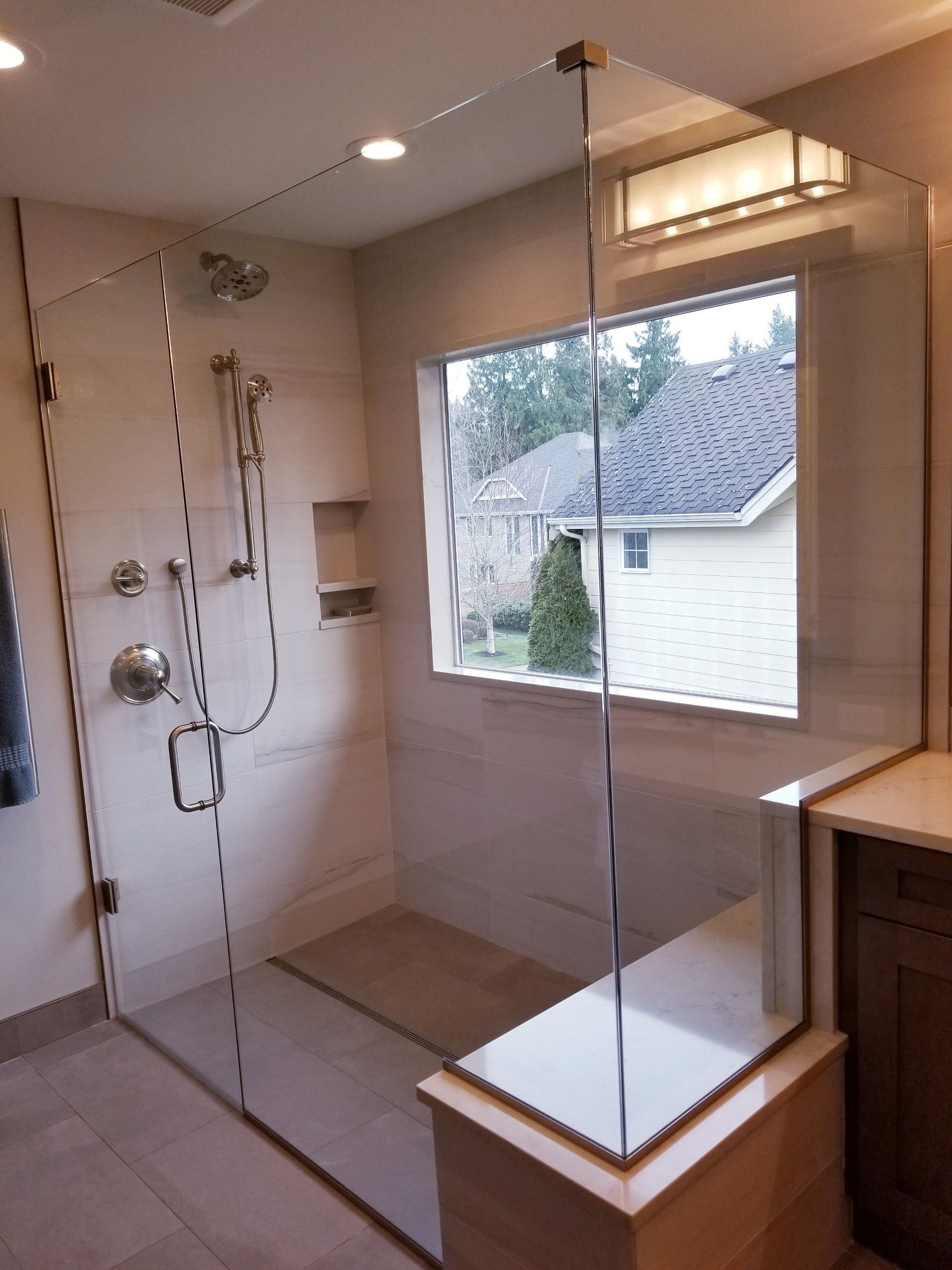 A bathroom with a walk in shower and a window