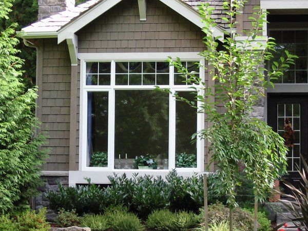 A house with a large window surrounded by trees