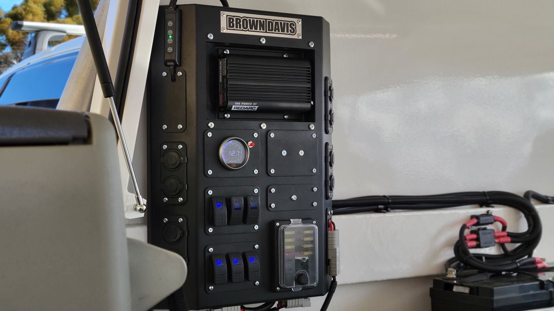 Camping tent illuminated at night, with fairy lights, chairs, and a small table.