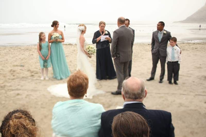 A bride and groom are getting married on the beach.