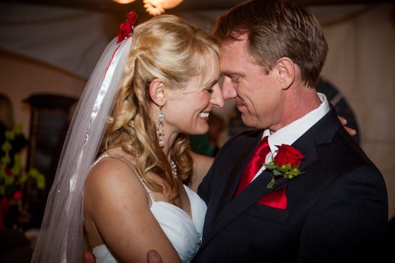 A bride and groom are looking into each other 's eyes.