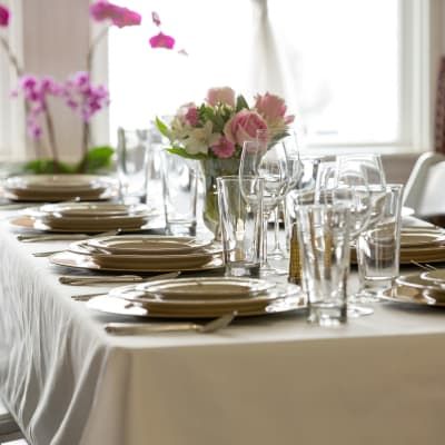 A long table with plates glasses and flowers on it