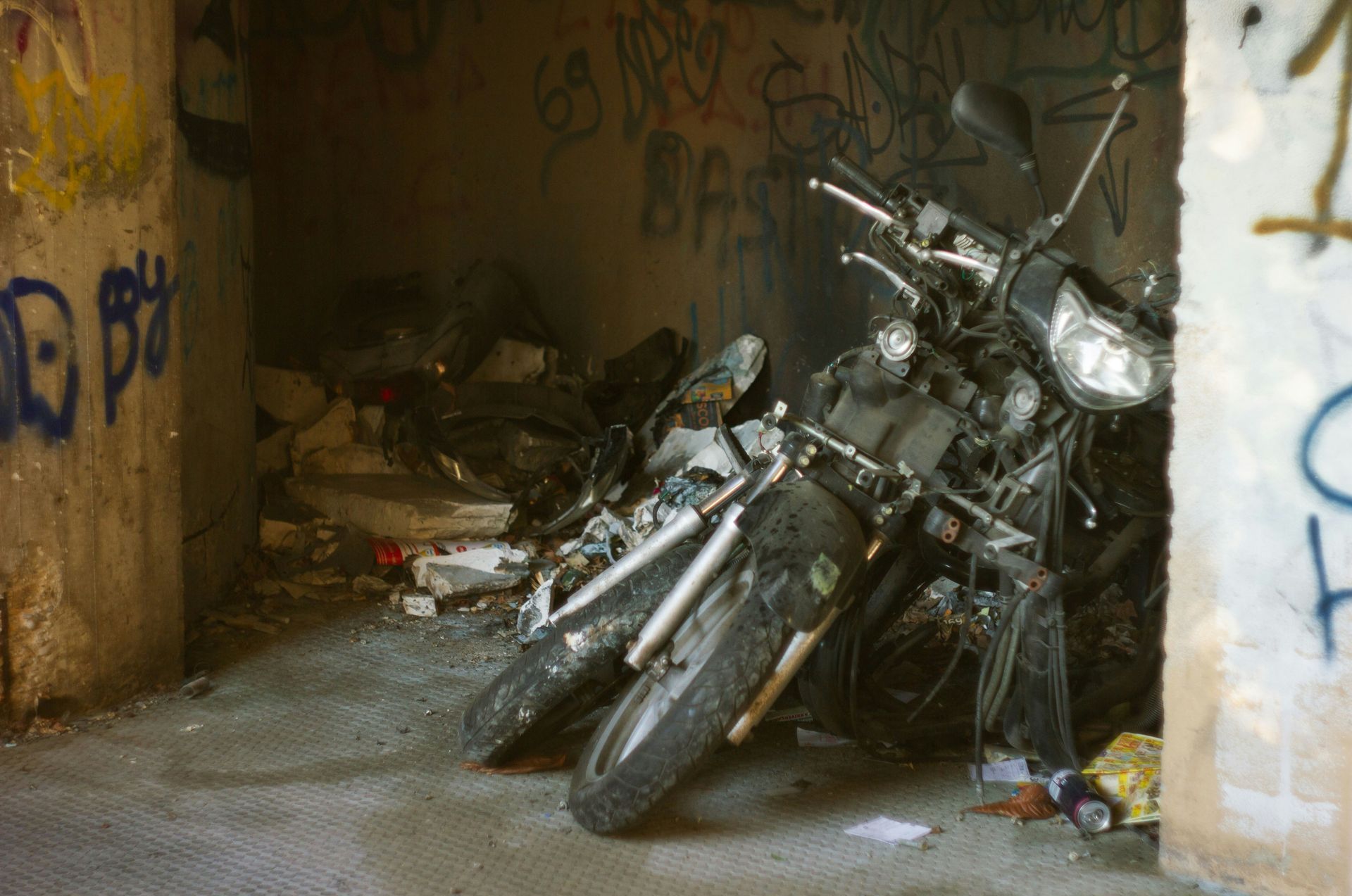 Two motorcycles are parked in a room with graffiti on the wall