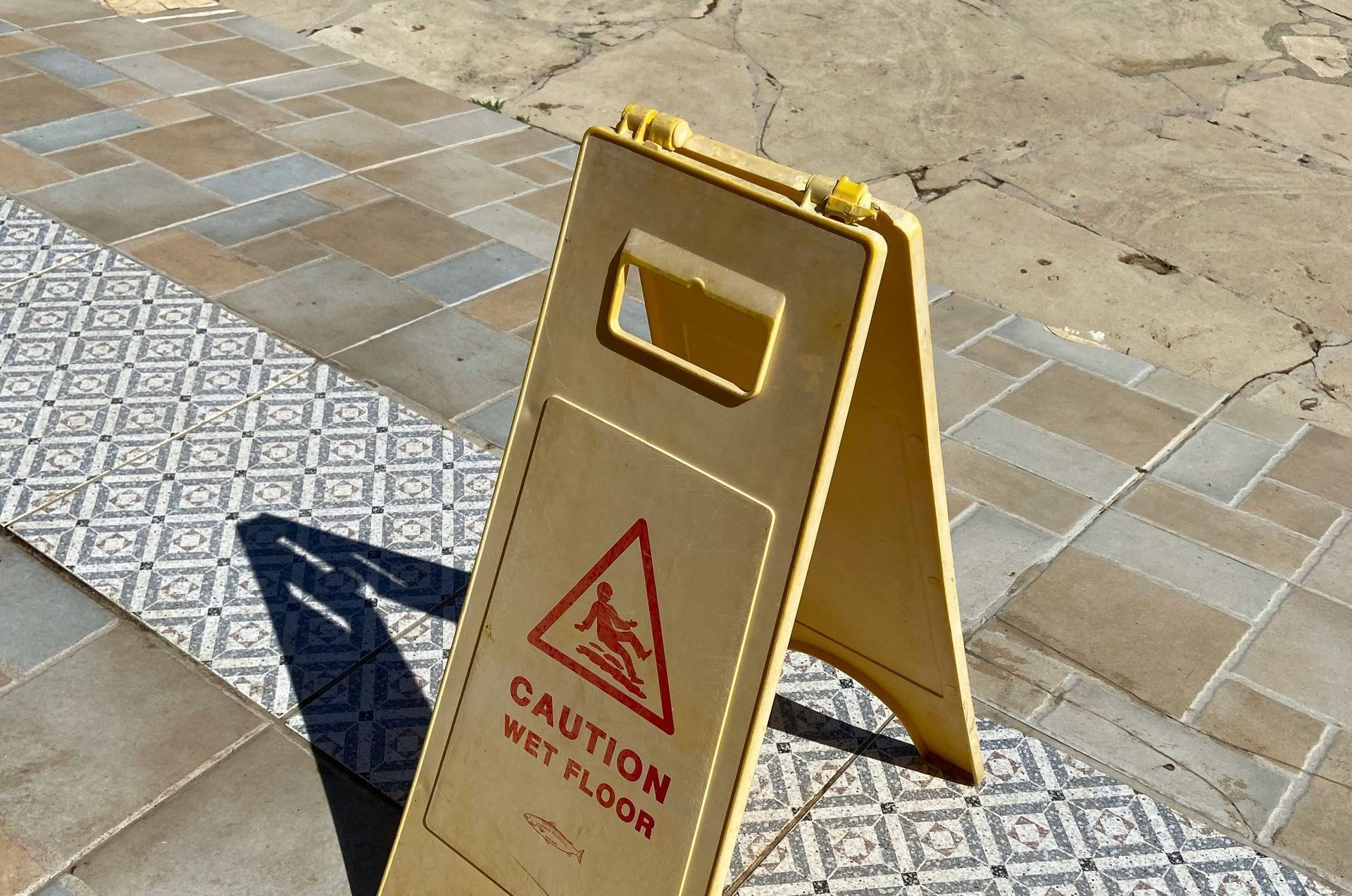 A caution wet floor sign on a tiled floor