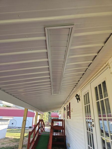 Covered porch with white ceiling, ramp, and double doors.