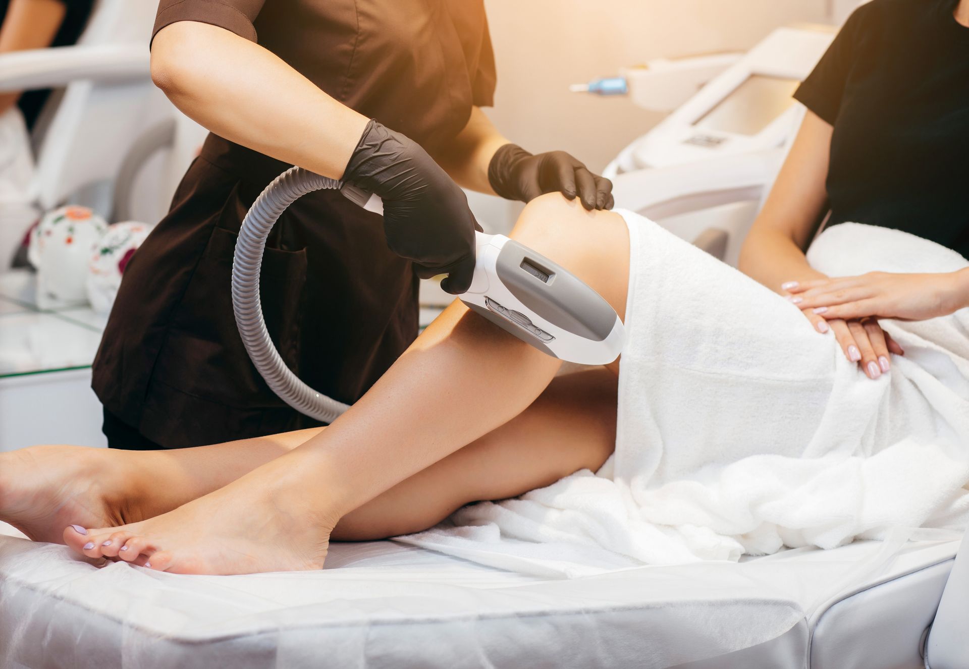 Laser hair removal treatment on a patient's leg in a spa clinic