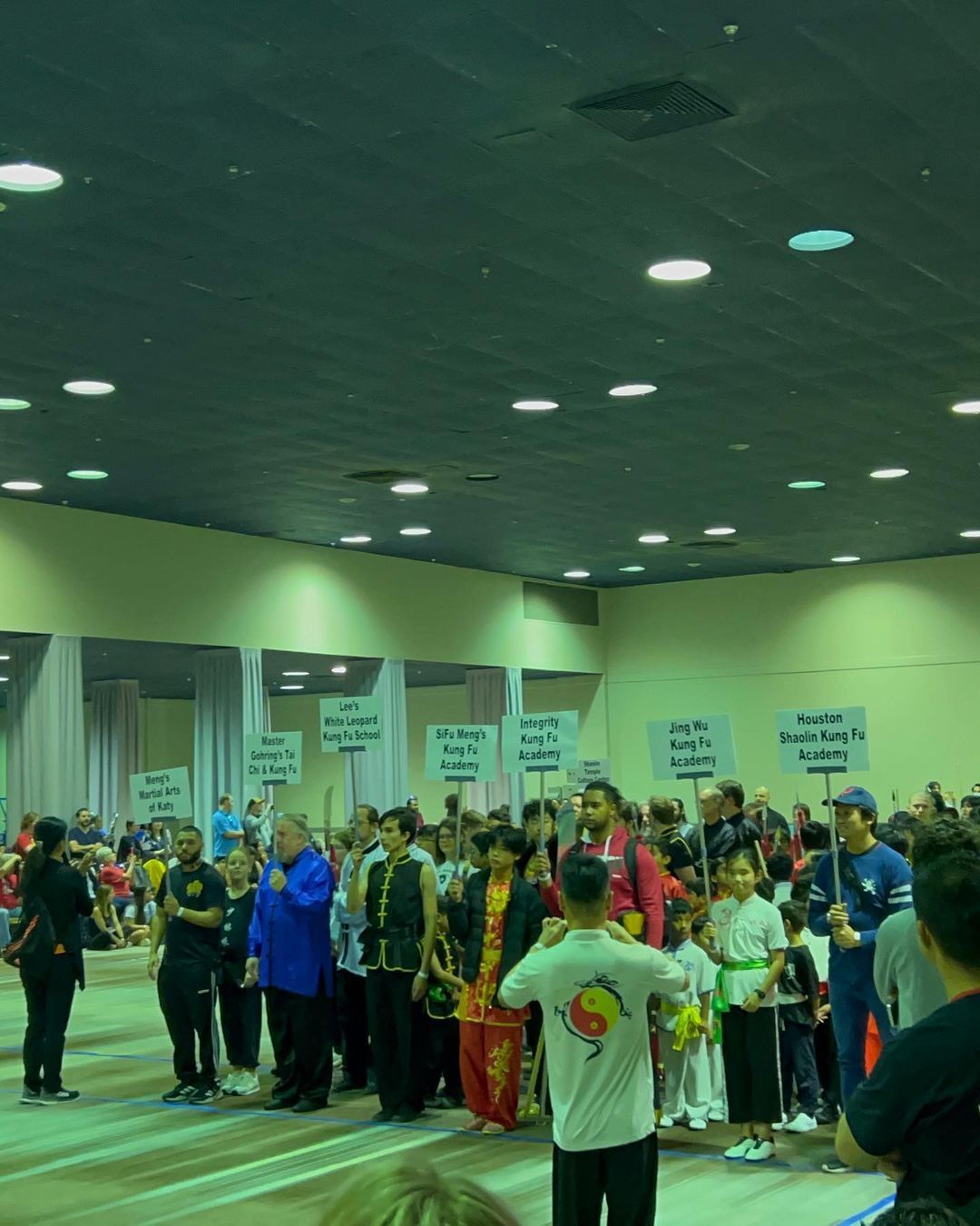 A group of people standing in a room with signs that say ' karate ' on them