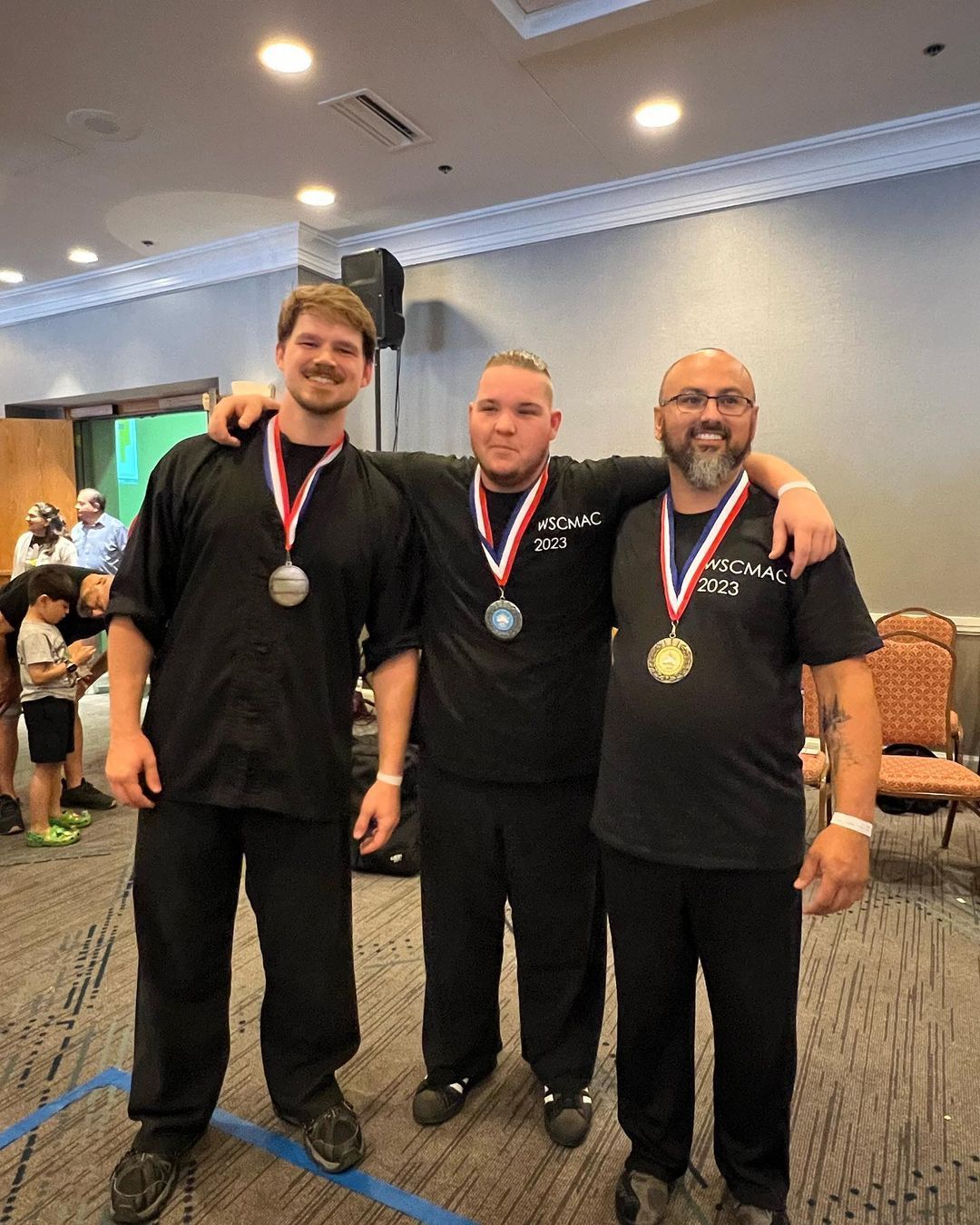 Three men are posing for a picture with medals around their necks.
