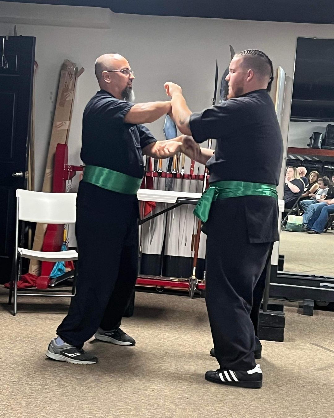 Two men are practicing martial arts in a gym.