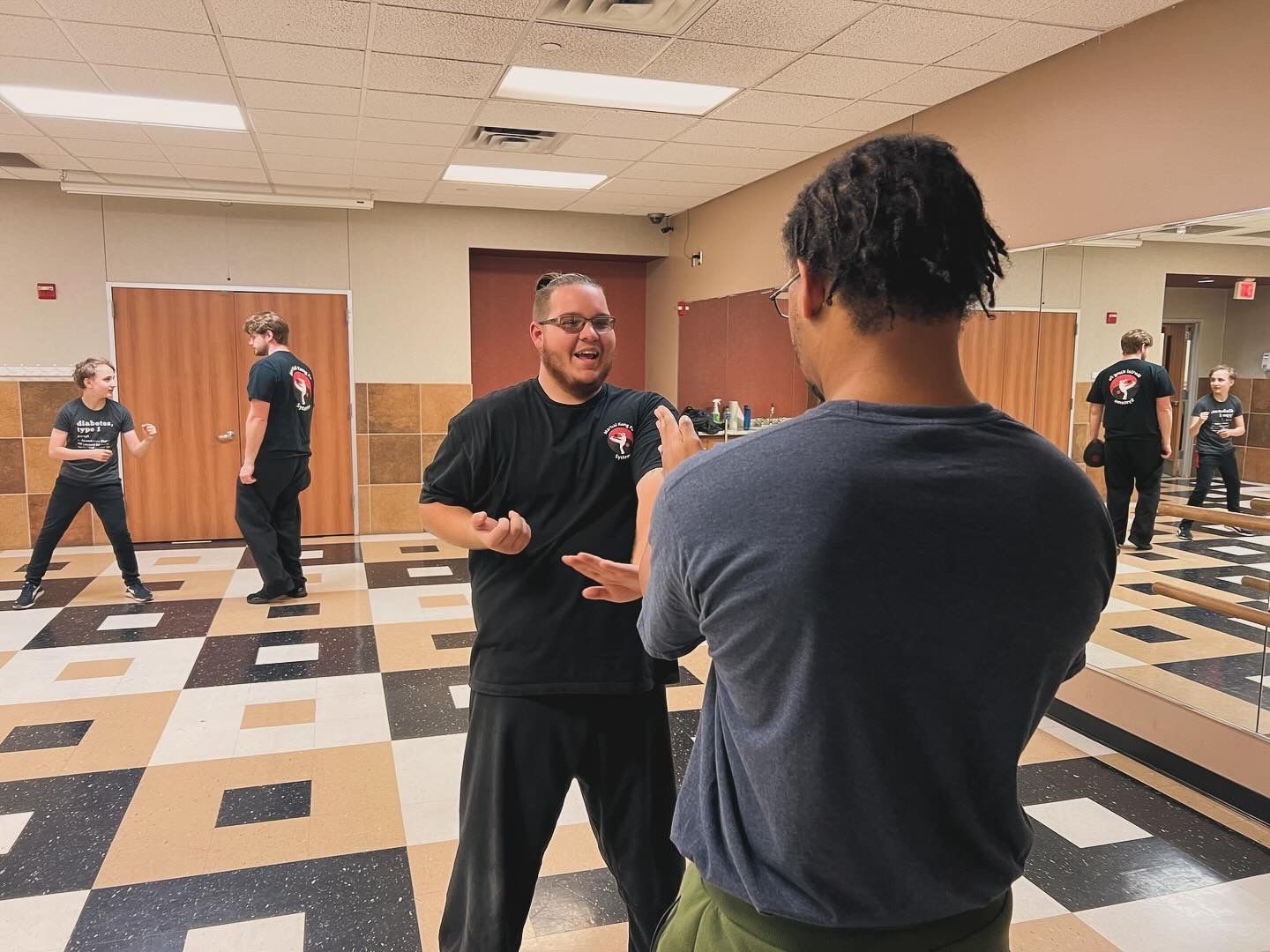 A group of men are standing in a room talking to each other.
