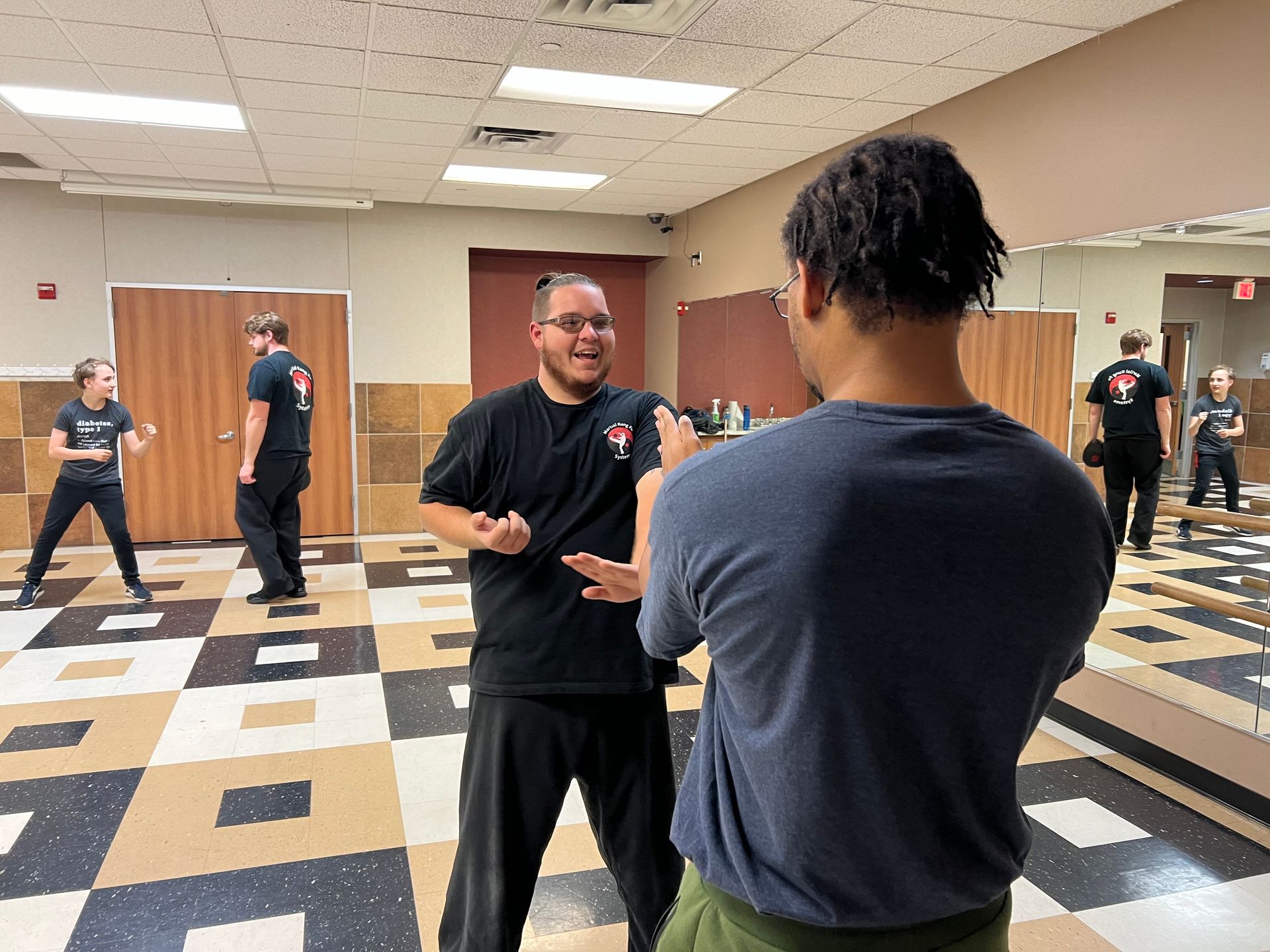 A group of men are standing in a room talking to each other.
