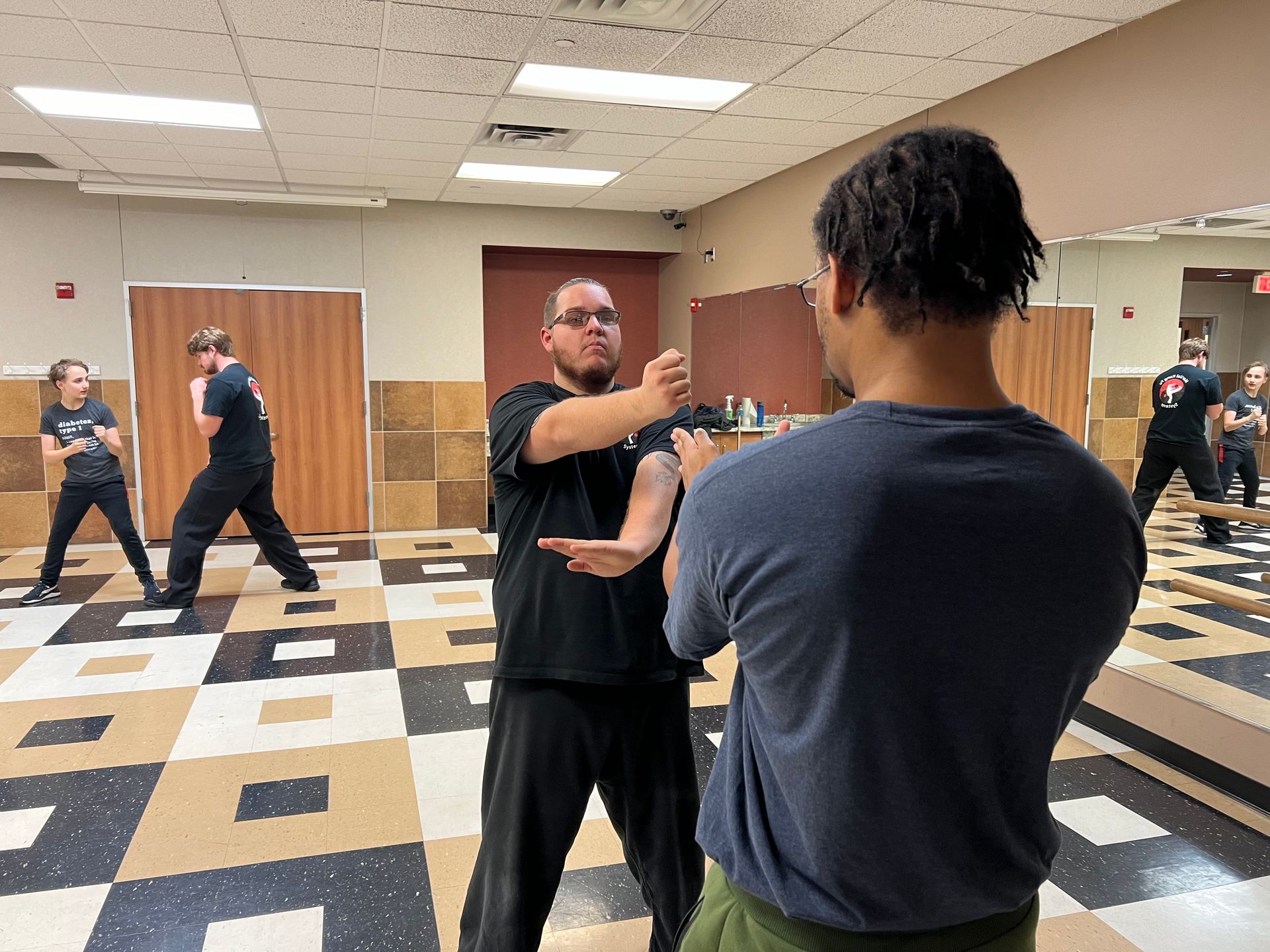 A group of men are practicing martial arts in a gym.