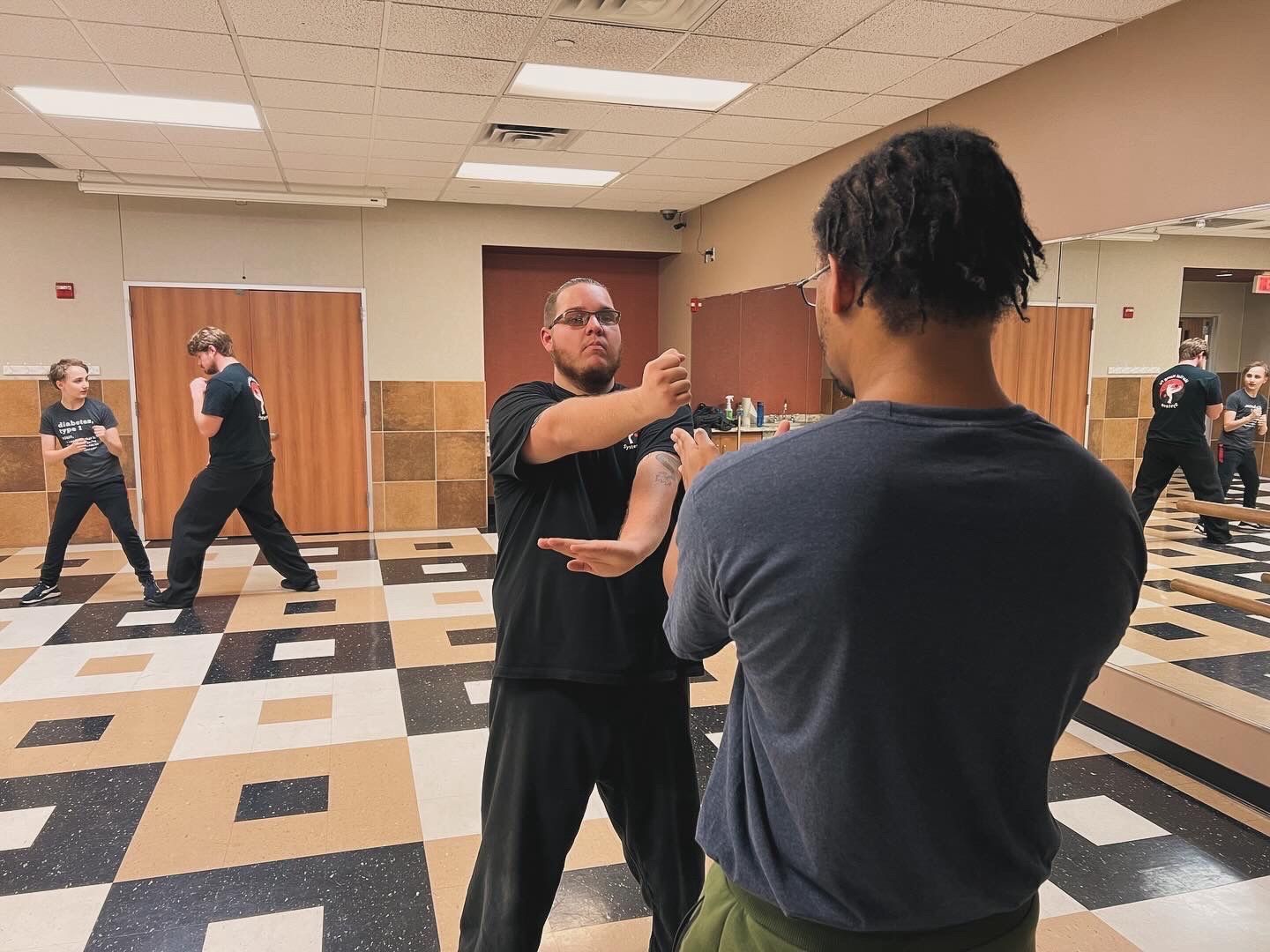 A group of men are practicing martial arts in a gym.