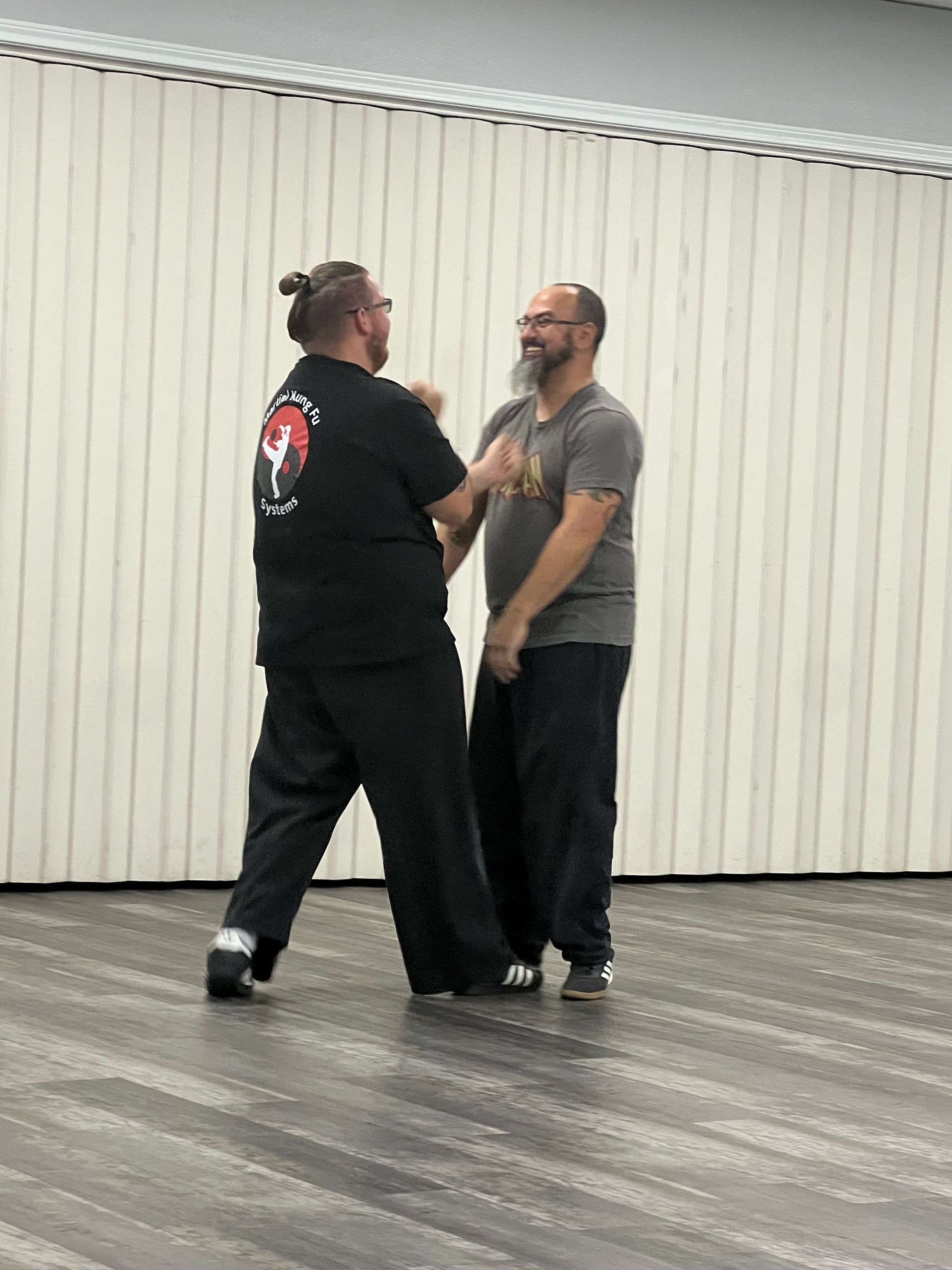 Two men are standing next to each other in a room.