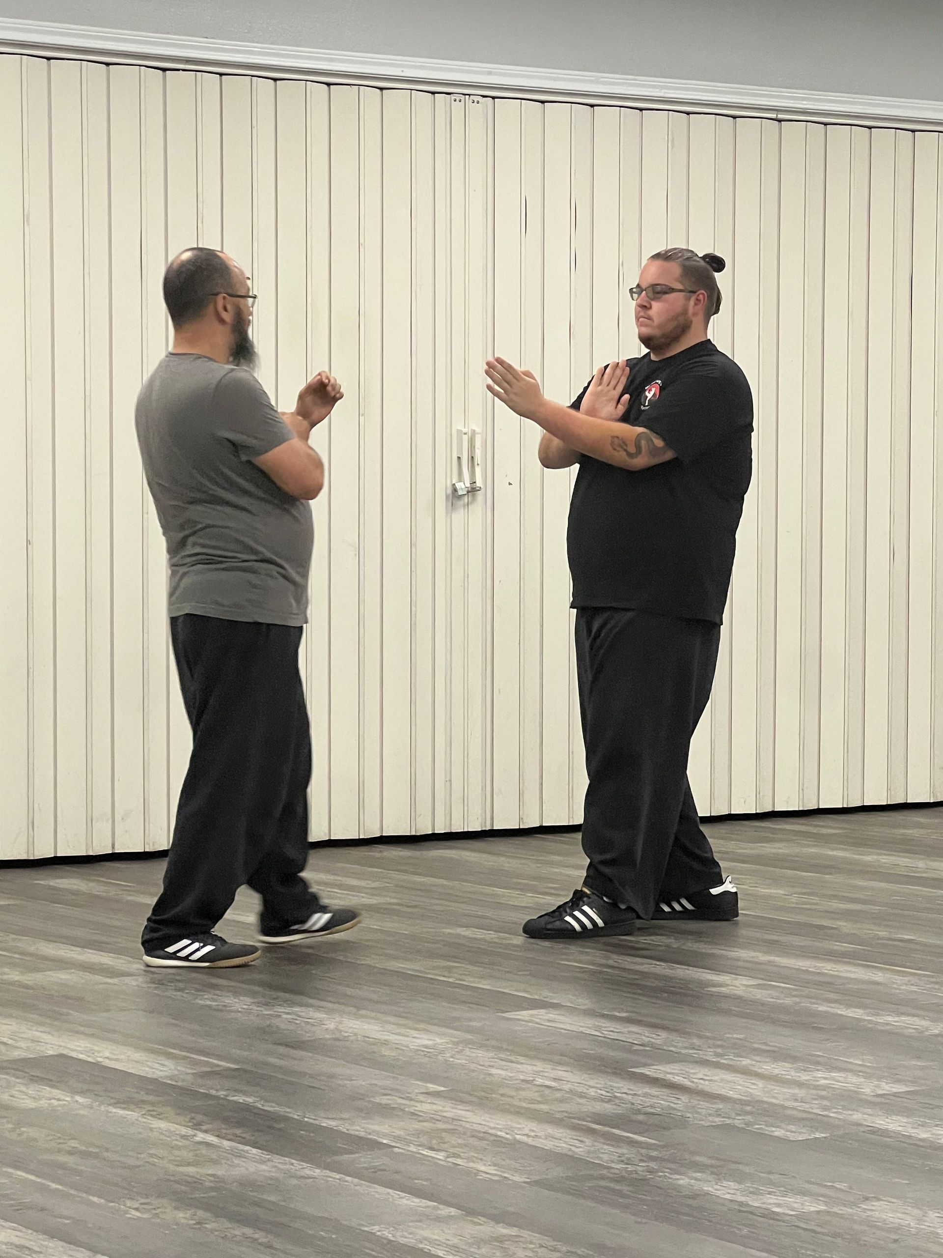 Two men are standing next to each other in a room.