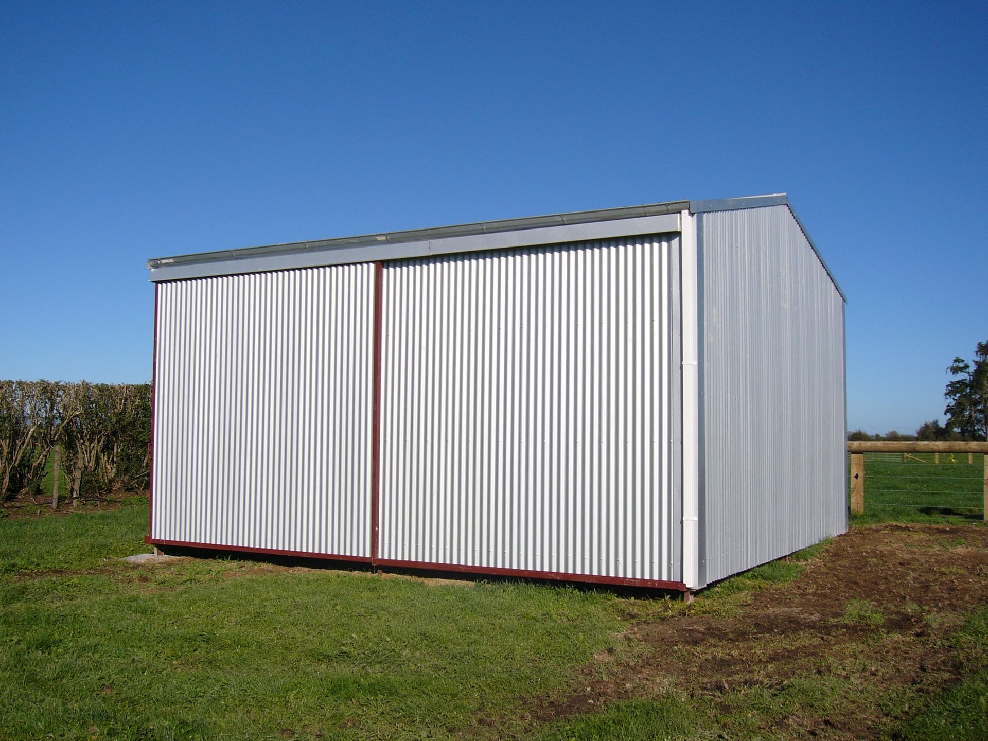 A green and red building with a fence in front of it