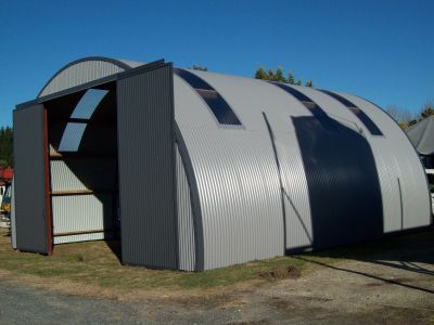 A large gray and black building with a sliding door