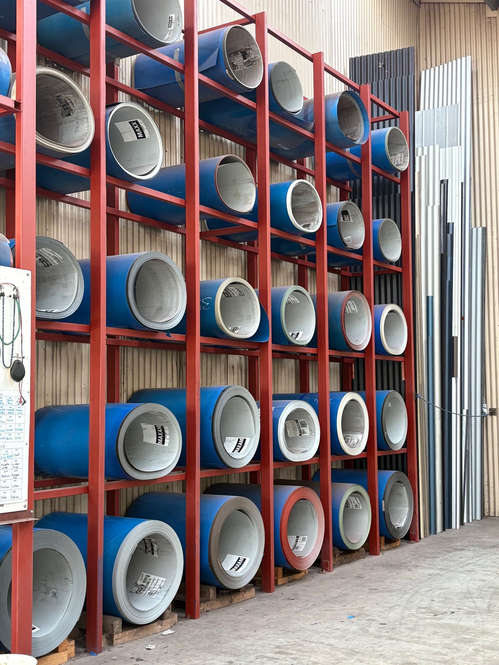 A bunch of pipes are stacked on top of each other in a warehouse.